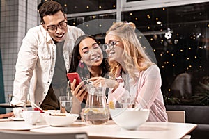 Couple persuading his female friend to write message to guy she liking.