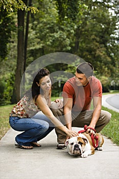 Couple petting dog.