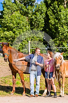 Couple petting horse on pony stable