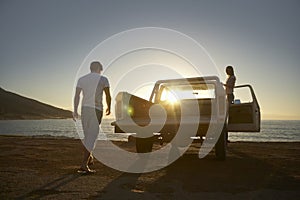 Couple By Pick-Up Truck Parked On Beach