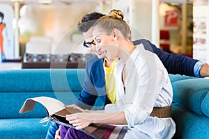 Couple picking couch seat cover in furniture store