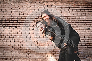 Couple in piggyback having a good time of laughter and love to celebrate their upcoming wedding