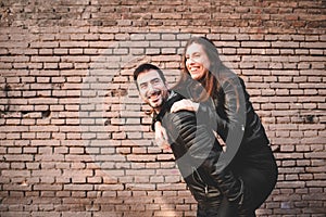 Couple in piggyback having a good time of laughter and love to celebrate their upcoming wedding