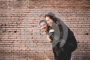 Couple in piggyback having a good time of laughter and love to celebrate their upcoming wedding