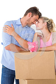 Couple with piggybank over cardboard box