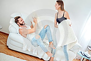 Couple pillow fight in a living room