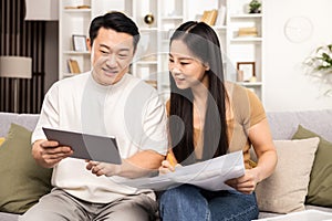 Couple Planning Budget with Tablet and Documents at Home