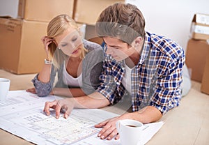 Couple, planning and house blueprints with moving boxes for home renovation, floor plan or property investment. Man