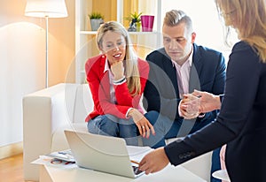 Couple planning their finances together with professional financial adviser photo