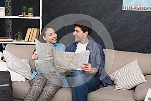 Couple planning trip, studying map at home