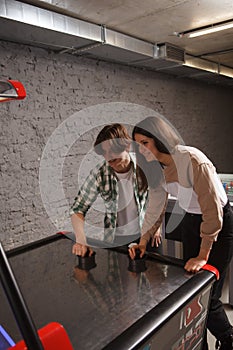 Couple playing air hockey together at college campus