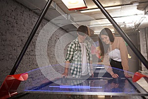 Couple playing air hockey together at college campus