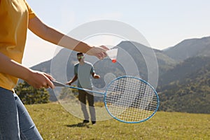 Couple playing badminton in mountains on sunny day