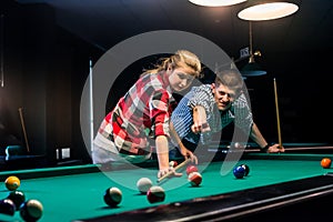Couple playing billiard, man showing ball to shot