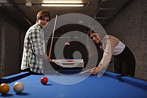 Couple playing billiard on a pool table