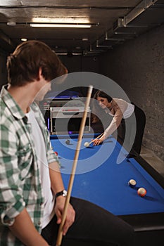 Couple playing billiard on a pool table