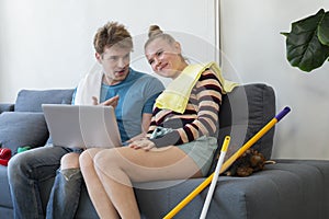 Couple playing doing chores. Cheerful couple having fun while doing housework together. Happy young Caucasian couple