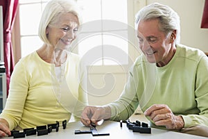 Couple playing dominos in living room smiling photo