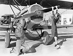 Couple playing with propeller on plane