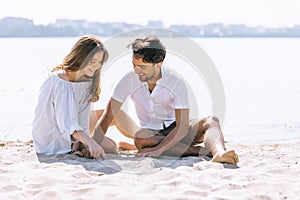 couple playing with sand on city beach