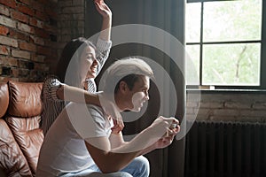 Couple playing video games together at home