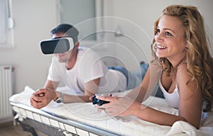 Couple playing videogames on bed