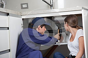 Couple plumbers fixing the pipes photo