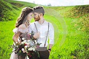 Couple portrait of a girl and guy looking for a wedding dress, a pink dress flying with a wreath of flowers on her head on a backg