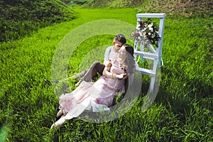 Couple portrait of a girl and guy looking for a wedding dress, a pink dress flying with a wreath of flowers on her head on a backg