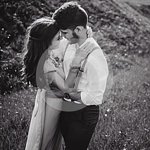 Couple portrait of a girl and guy looking for a wedding dress, a pink dress flying with a wreath of flowers on her head on a backg