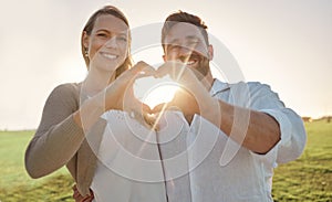 Couple, portrait and heart hand with sun for romantic date on beautiful field in Ireland. Love, happy and smile of