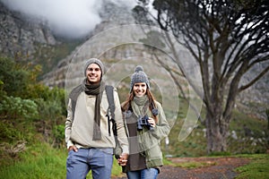 Couple, portrait and hiking on mountain or holding hands with travel, adventure or holiday for experience or love. Man