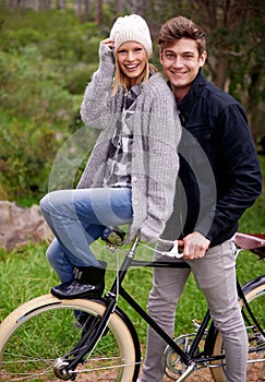 Couple, portrait and park with retro bicycle on holiday, adventure and date with sustainable transport. Man, woman and