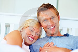 Couple, portrait and smile in bed of home for love, care and relax for holiday, break and support together. Man bond