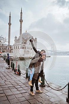 couple portrait smiling while visiting ortakoy mosque