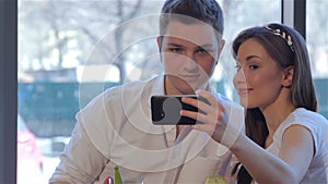 Couple poses to a selfie at the cafe