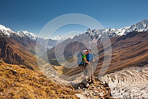 Couple is posing to the camera in front of Manaslu valley in highlands of Himalayas