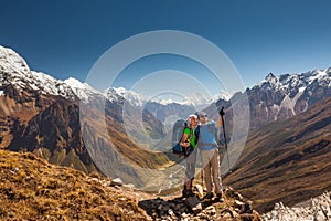 Couple is posing to the camera in front of Manaslu valley in highlands of Himalayas
