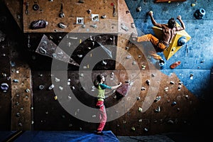 Couple practicing rock-climbing on a rock wall