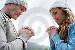 Couple praying with hands clasped