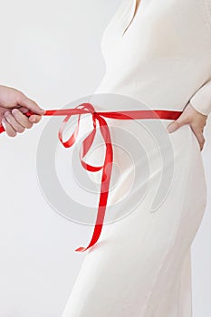 Couple pregnancy photo with ribbon wrapped on belly