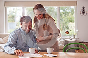 Couple With Pregnant Wife Reviewing Domestic Finances Together