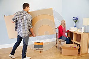 Couple Preparing To Assemble Flat Pack Furniture In Nursery photo
