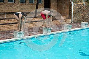 Couple preparing to dive in pool