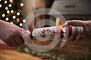 Couple Pulling Cracker In Room Decorated For Christmas