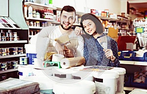 Couple purchasing tools for house improvements in paint supplies