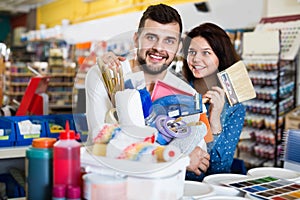 Couple purchasing tools for house improvements in paint supplies store