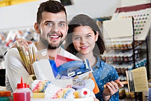 Couple purchasing tools for house improvements in paint supplies store