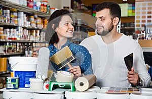 Couple purchasing tools for house improvements in paint supplies store