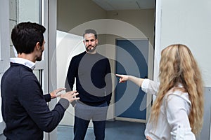 Couple Quarreling With Man Standing Outside The Door